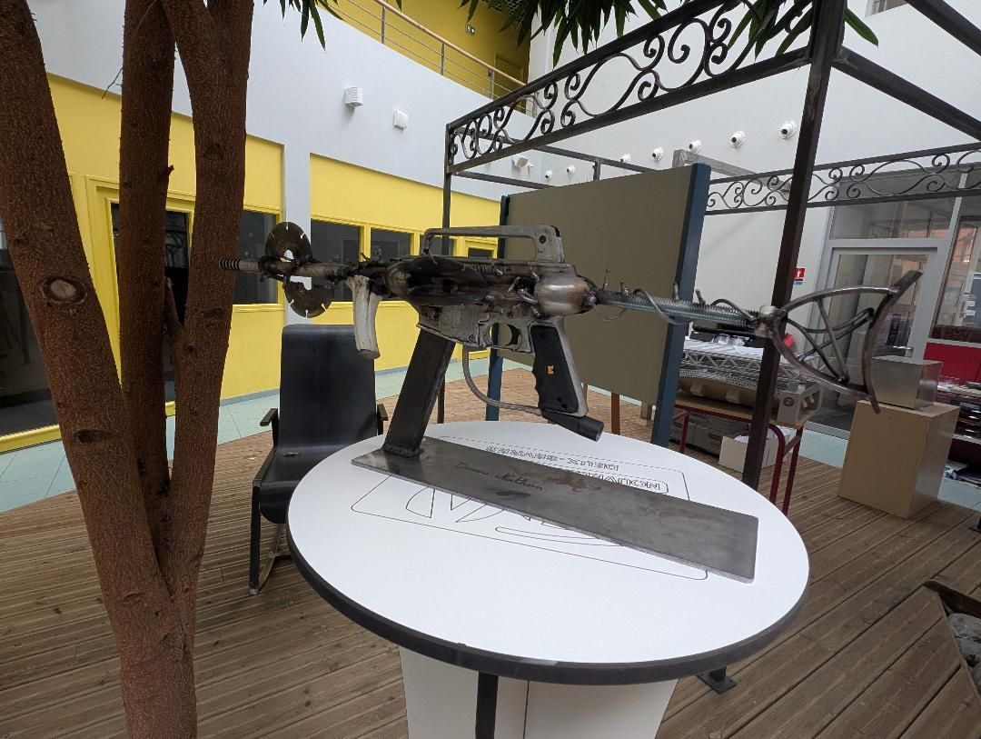 Sculpture de fusil en métal exposée sur une table